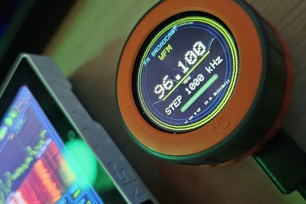An M5Stack Dial running OrcDial, showing FM broadcast 96.100 MHz with a 1000 kHz step, next to a Tab5 showing the matching spectrum