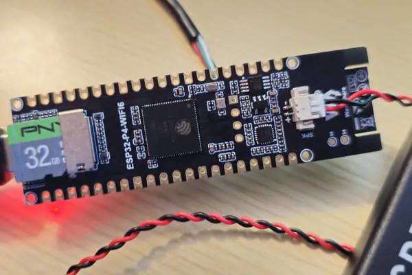 A Waveshare ESP32-P4-WIFI6 board with a microSD card fitted, wired to a speaker lead, beside an RTL-SDR dongle